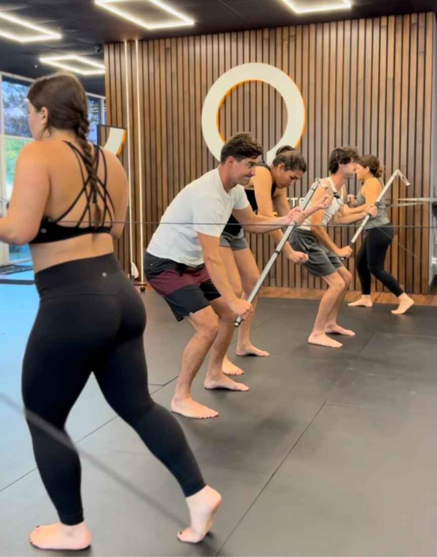 A semi-private Functional Patterns group performing a coordinated drill at the Costa Mesa studio.